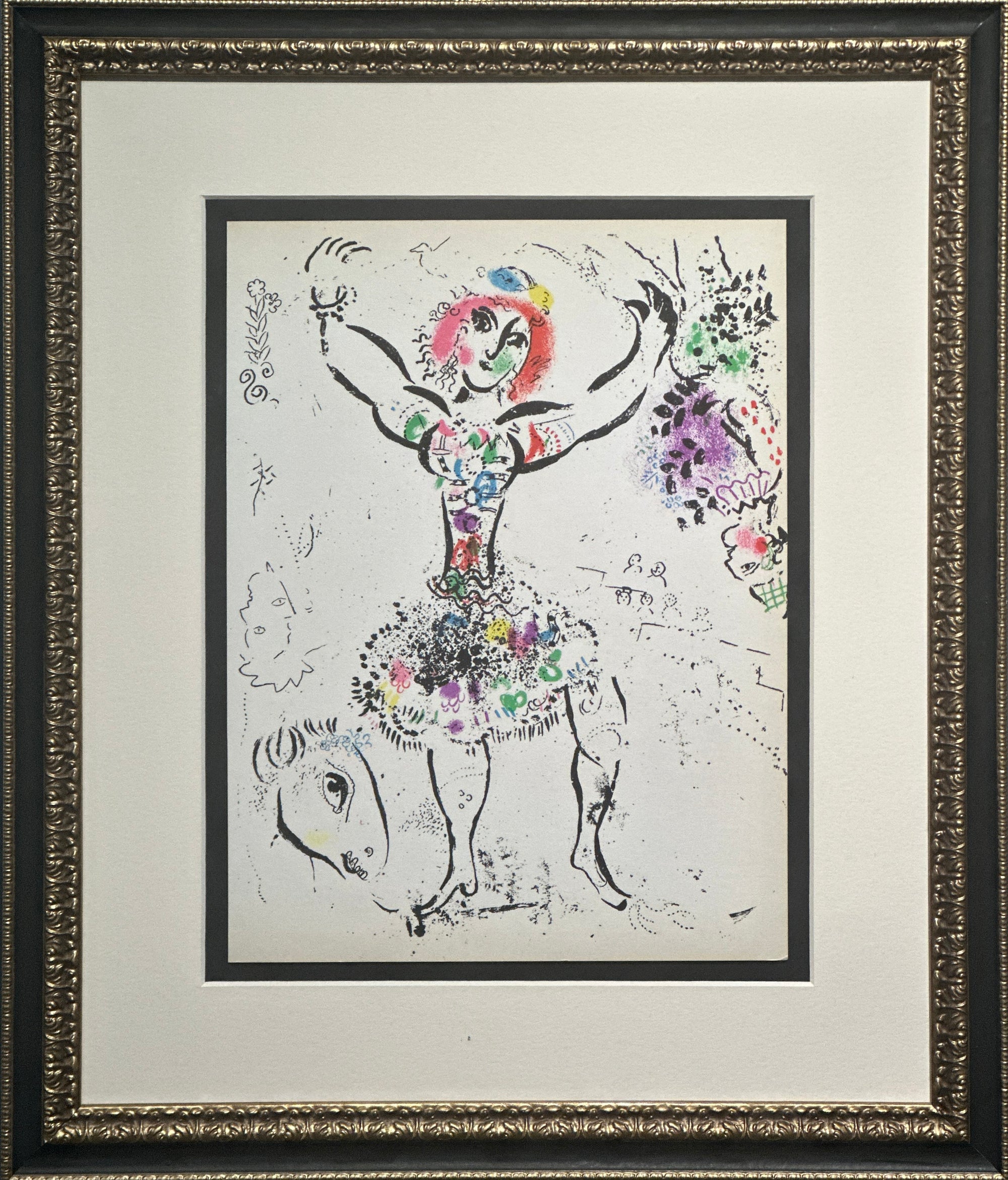 Framed artwork featuring a whimsical black ink-style drawing of a woman with raised arms and a horse, filled with colorful floral and patterned details, set within a white mat and ornate dark frame.