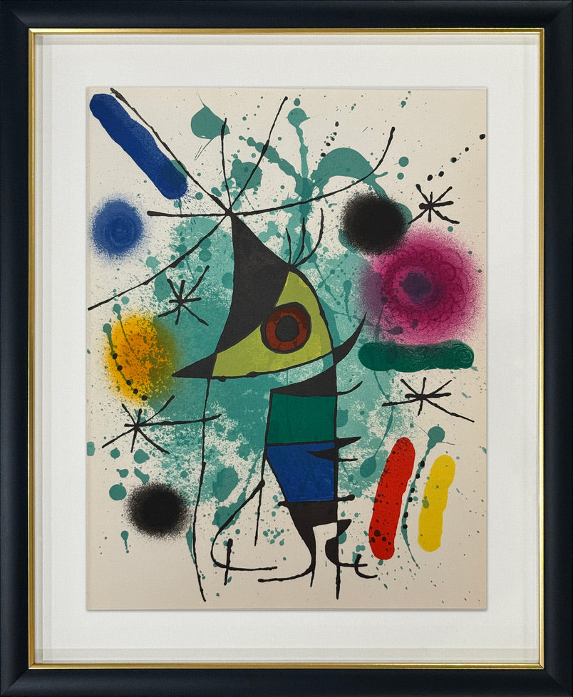 A framed abstract artwork featuring a central triangular figure with a red eye, surrounded by colorful paint splatters, brushstrokes, and black gestural lines on a cream background. The piece is matted with a white mat and enclosed in a black frame with a gold inner border.