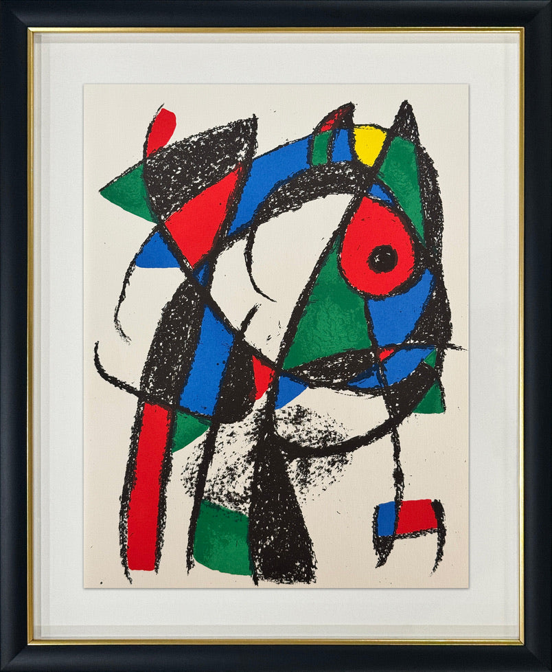 A framed abstract geometric artwork featuring bold black, red, blue, green, white, and yellow shapes on a cream background, presented in a black frame with a gold inner border and white mat.