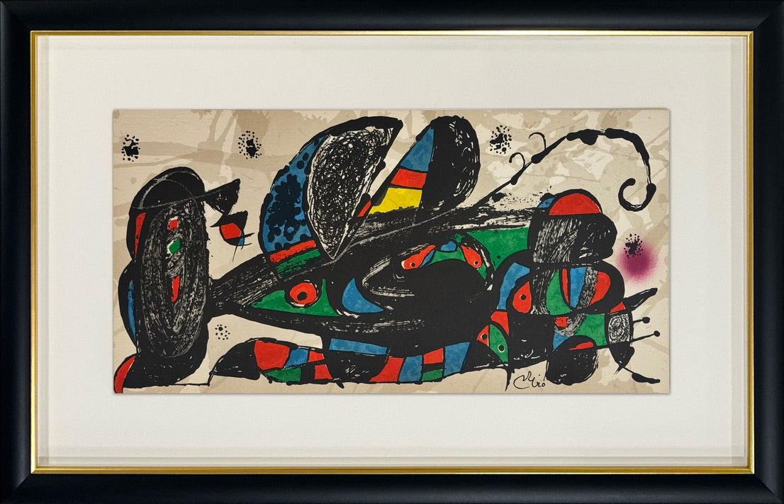 A framed abstract art print featuring bold black, blue, green, red, and yellow shapes on a beige background, surrounded by a white mat and a black frame with a gold inner border.